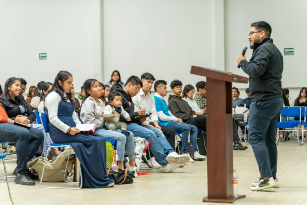 A speaker presenting to a diverse audience at a gathering in Ciudad de México, highlighting community engagement.